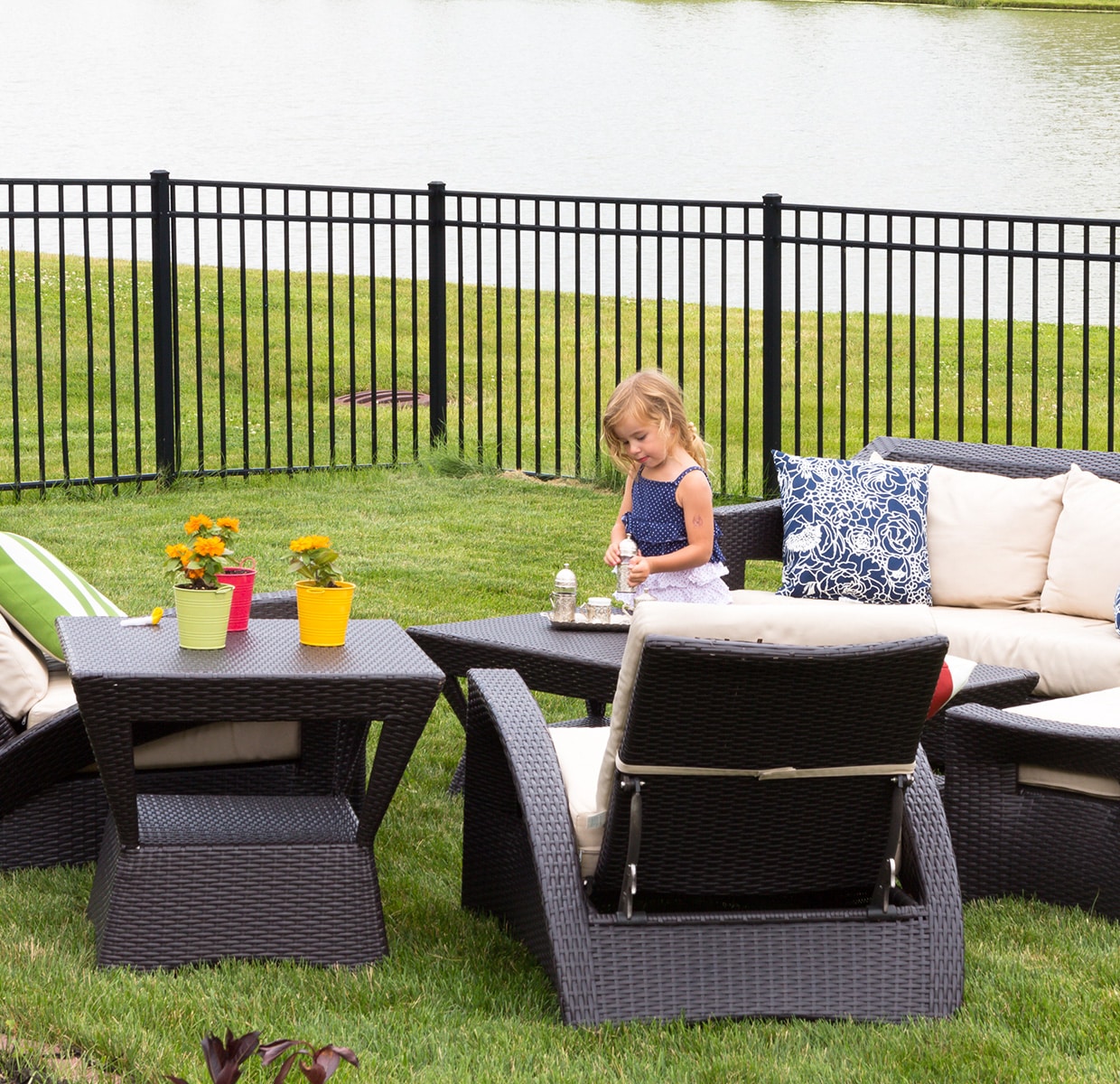 Little girl playing in fenced-in yard