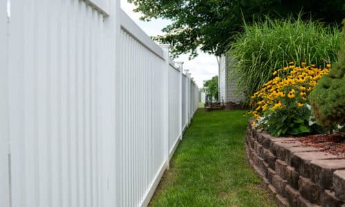 White vinyl fence near large garden